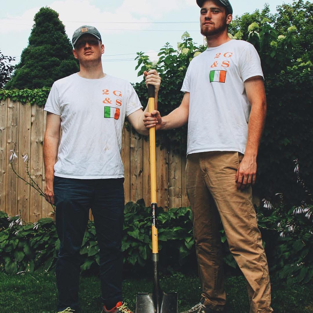 Johnny and his brother in 2 G & S shirts holding a shovel